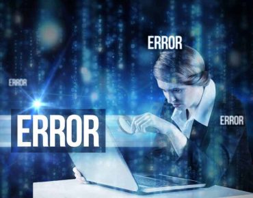 The word error and redhead businesswoman using her laptop against lines of blue blurred letters falling